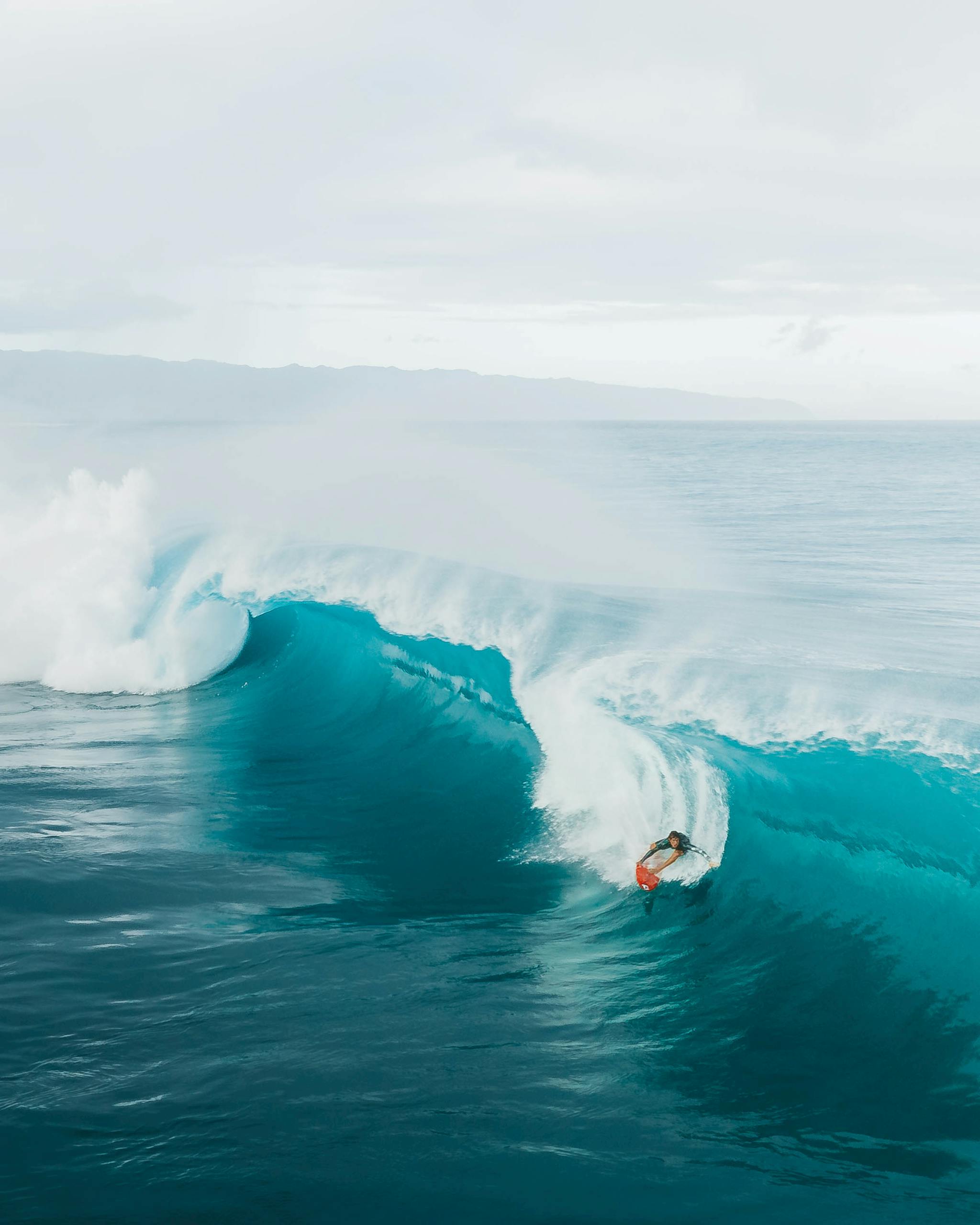 A surfer skillfully rides a large wave at Haleiwa Beach in Oahu, capturing the essence of adventure and excitement.