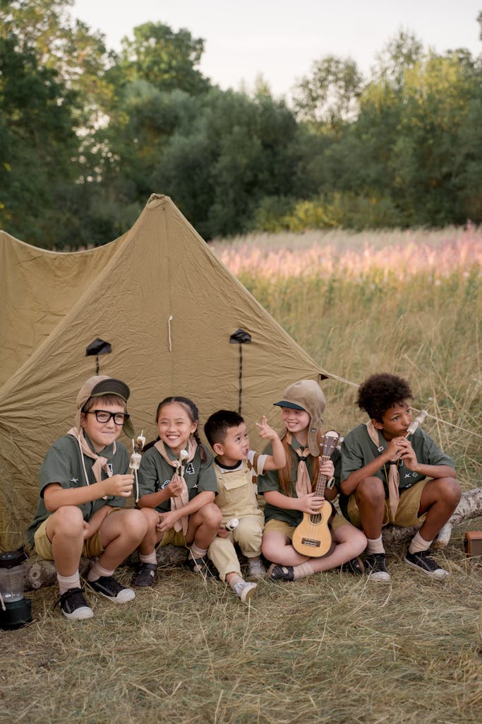 A diverse group of kids in scout uniforms camping, playing music, and having fun outdoors.