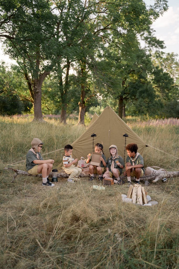 A group of children enjoy a summer camping adventure, surrounded by nature and tents.